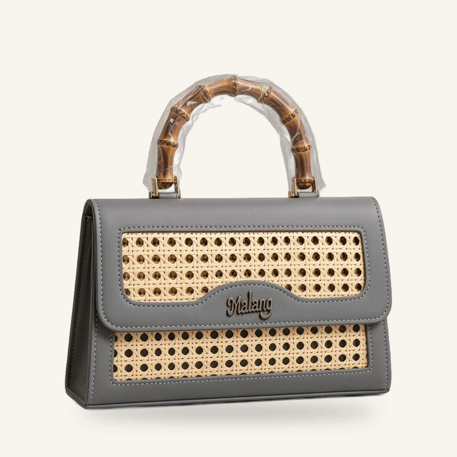 The Malang Top Handle — grey cane and vegan-leather handbag with bamboo handle, on an ivory background